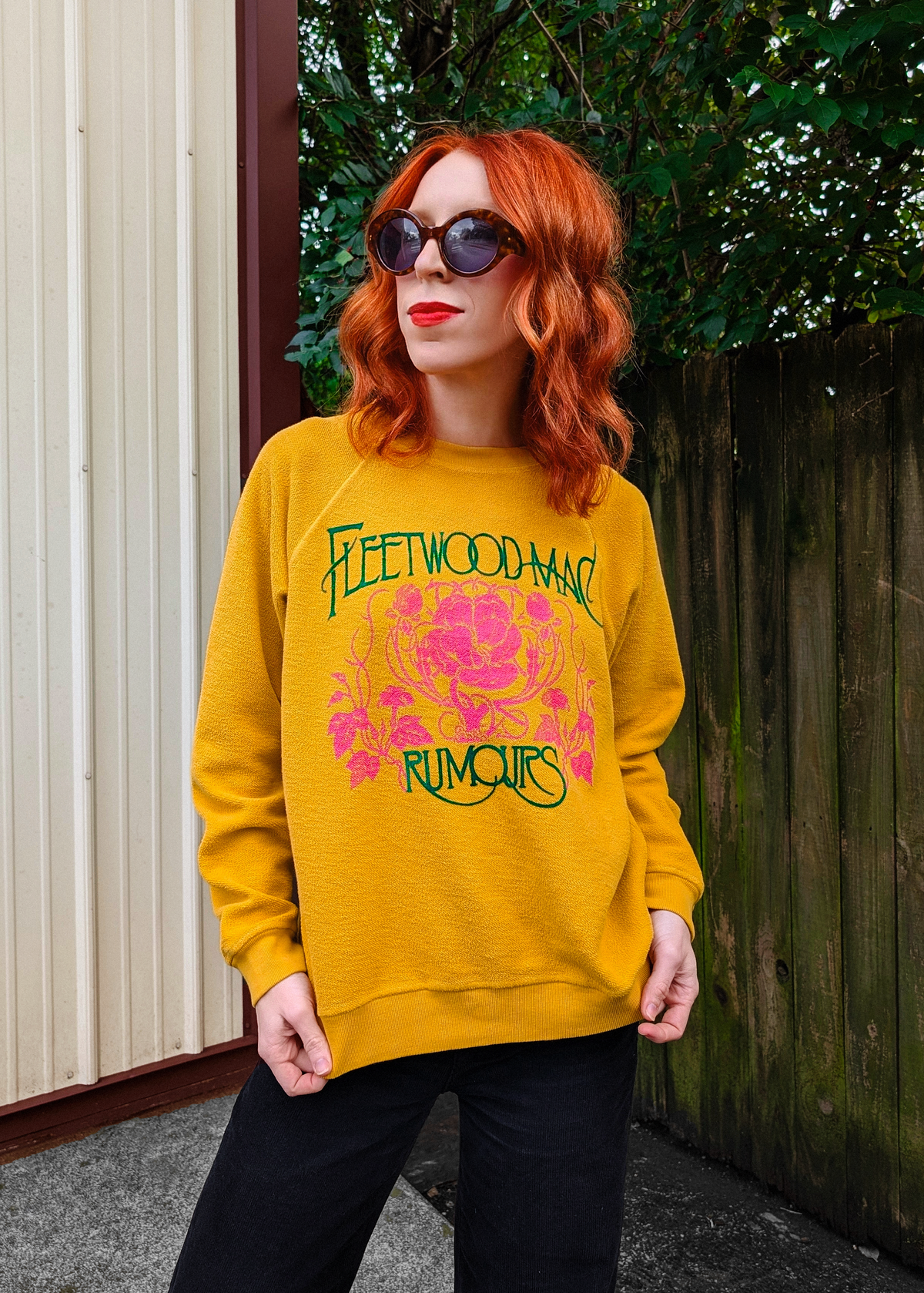 Fleetwood Mac Rumours sweatshirt with a reversed inside out textured look. Features a crew neckline, raglan sleeves, and ribbed cuffs, neckline, and hem. Golden Daze mustard colorway with flocked velvet writing in green and pink floral details. 100% French terry, made in the USA. Slouchy, relaxed fit 